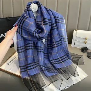 Detail of blue and black plaid silk scarf with gold threads and mesh trim detail