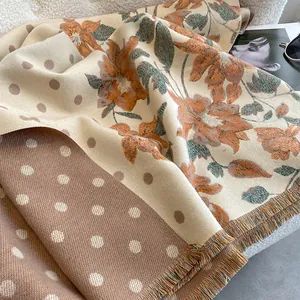 Detail of floral and polka dot patterns on thick reversible pashmina with fringe