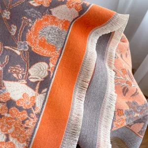 Detail of floral jacquard cashmere-feel scarf with orange and grey tassels