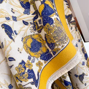 Close-up of vintage flower and bird pattern with fringe detail on thick cashmere scarf