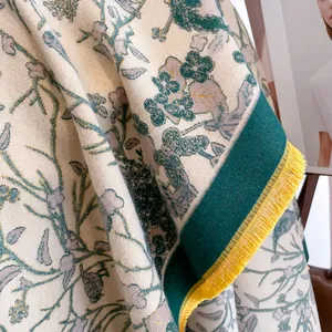 Close-up of vintage floral cashmere-like scarf with green botanicals and yellow tassels