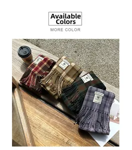 Detailed view of plaid cashmere-like scarves with fringe on a rustic wooden bench