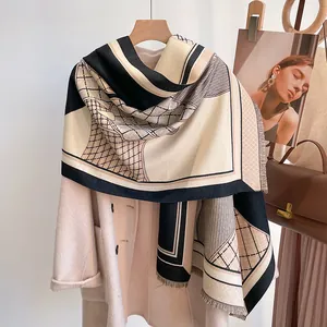 Elegant cashmere-like scarf with horse pattern and tassels draped on a wool coat