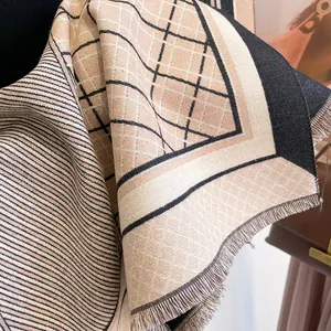 Close-up of thick winter scarf showing horse pattern knit and fringed tassel edges
