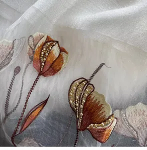 Detailed close-up of floral embroidery with pearls on white silk blend shawl