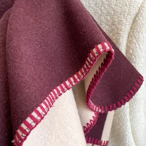 Close-up of contrast hand-stitched edges on thick burgundy cashmere-like scarf