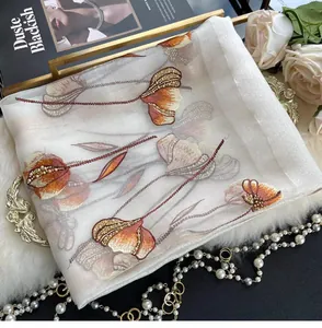 Detail of white silk blend scarf with orange floral embroidery and beaded accents