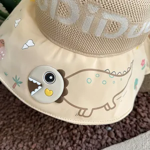 Detail of children's sun hat featuring a 3D dinosaur ornament and breathable mesh fabric