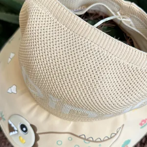 Detail of kids sun hat featuring cute dinosaur patterns and knitted headband texture