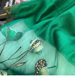 Detail view of exquisite green floral embroidery with pearls and beads on silk mesh shawl