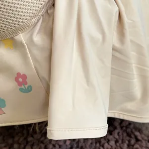 Close-up of beige fabric with floral star pattern and fine stitching on a sun hat
