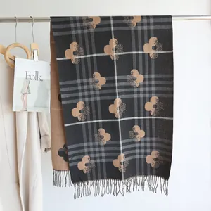 Detail of elegant cashmere-feel scarf with vintage floral patterns and fringe tassels