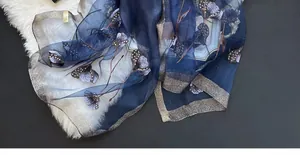 Detailed embroidery and beadwork on dark blue silk blend scarf with silver edges