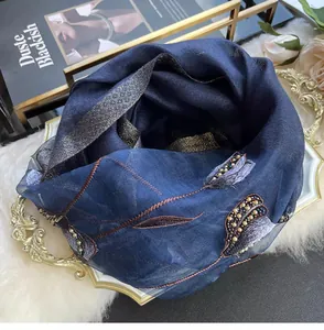 Detail of silk scarf with floral embroidery and beads on a golden vintage tray