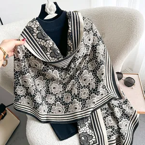 Detail of floral pattern cashmere-like scarf with lace weave and elegant stripe edge
