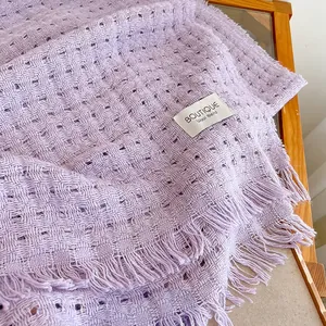 Detail van lavendelkleurige wollen sjaal met opengewerkte textuur en elegante franjes
