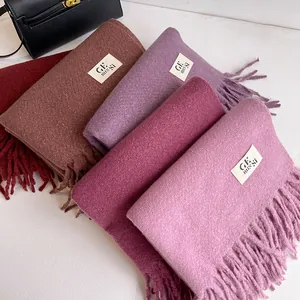 Detail shot of various solid-colored pashmina scarves with long handmade tassels