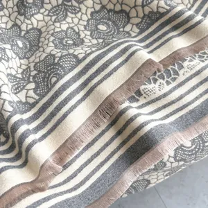 Close-up of floral cashmere scarf with vintage lace patterns and tassel edges