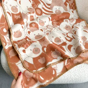 Detail of caramel bear pattern scarf with soft knitted texture and premium lockstitch edge
