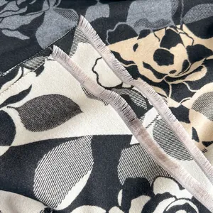 Dettaglio della sciarpa floreale in finto cashmere con nappe viola e trama spessa