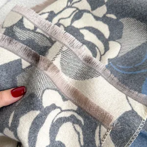 Dettaglio di sciarpa floreale simil-cashmere con trama morbida e bordi con frange