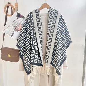 Detail of soft black and white knit shawl with fringe and geometric spiral pattern