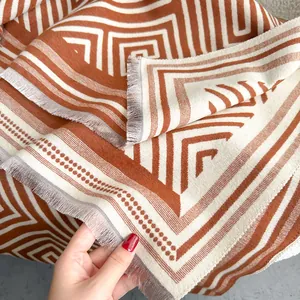 Detailansicht des Labyrinth-Kaschmirschals mit weichen Fransen in Ziegelrot und Beige