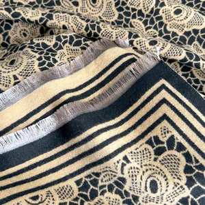 Detail of floral cashmere-like scarf showing intricate lace patterns and silver fringe