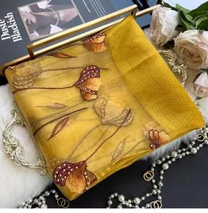 Detail of golden silk blend scarf with elegant floral embroidery and beadwork accents