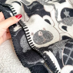 Close-up of thick bear pattern scarf showing plush texture and black knitted edges