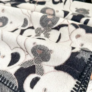 Detailed macro view of soft cashmere-like fabric with cute panda pattern and black overlocked edges