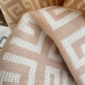 Close-up of camel and white Greek Key pattern cashmere-feel scarf fabric texture