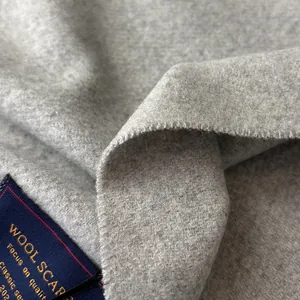 Detailed close-up of gray wool scarf fabric texture with a classic woven label