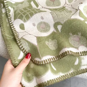Detail of the avocado green bear pattern scarf with double-sided jacquard knitting