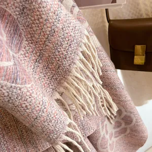 Detail of pink and purple tweed shawl featuring camellia pattern and fringe edges