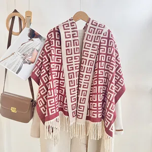 Detail of red and beige geometric pattern shawl with dense fringe on a stylish long coat