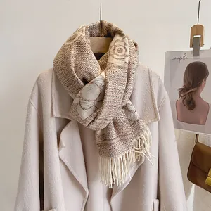 Close-up of knit camellia scarf with thick floral pattern and soft fringe tassels