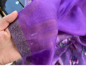 Detail of purple silk blend scarf featuring gold trim and delicate floral embroidery