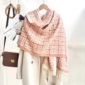 Detailed close-up of pink and cream geometric 4G pattern knit scarf with tassel fringe