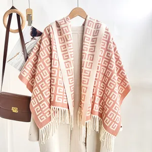 Detail view of pink and beige geometric knit shawl with elegant tassel fringe edges