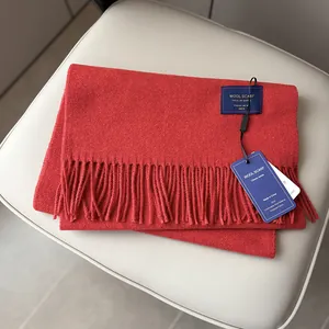 Detail of red Australian wool scarf with dense fringe and classic woven brand label