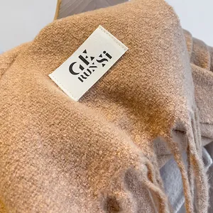 Classic camel textured scarf with long tassels and minimalist brand label detail