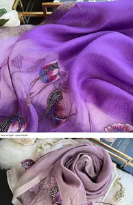Détail d'une écharpe en soie mauve avec broderies florales et perles délicates