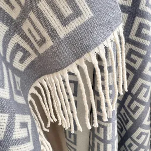 Close-up of grey and beige Greek key weave pattern and soft fringe detail