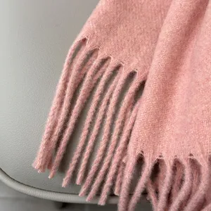 Detail shot of soft pink wool scarf showing high-quality fluffy texture and tassels