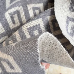 Detailed macro view of the soft grey and white Greek key pattern on thick pashmina shawl