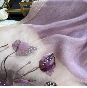 Detailed close-up of intricate purple floral embroidery and handcrafted beadwork on silk shawl