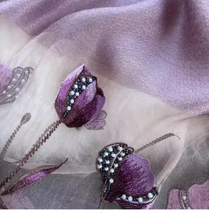 Close-up of elegant purple silk scarf with floral embroidery and pearl bead details
