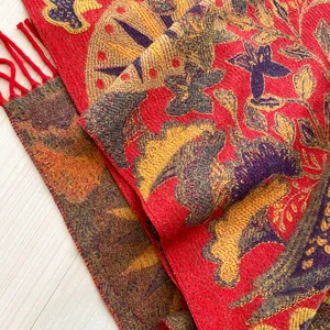 Détail du châle ethnique en maille avec franges rouges et motifs solaires rétro
