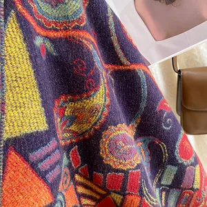 Close-up of thick ethnic knit scarf with colorful paisley patterns and purple base